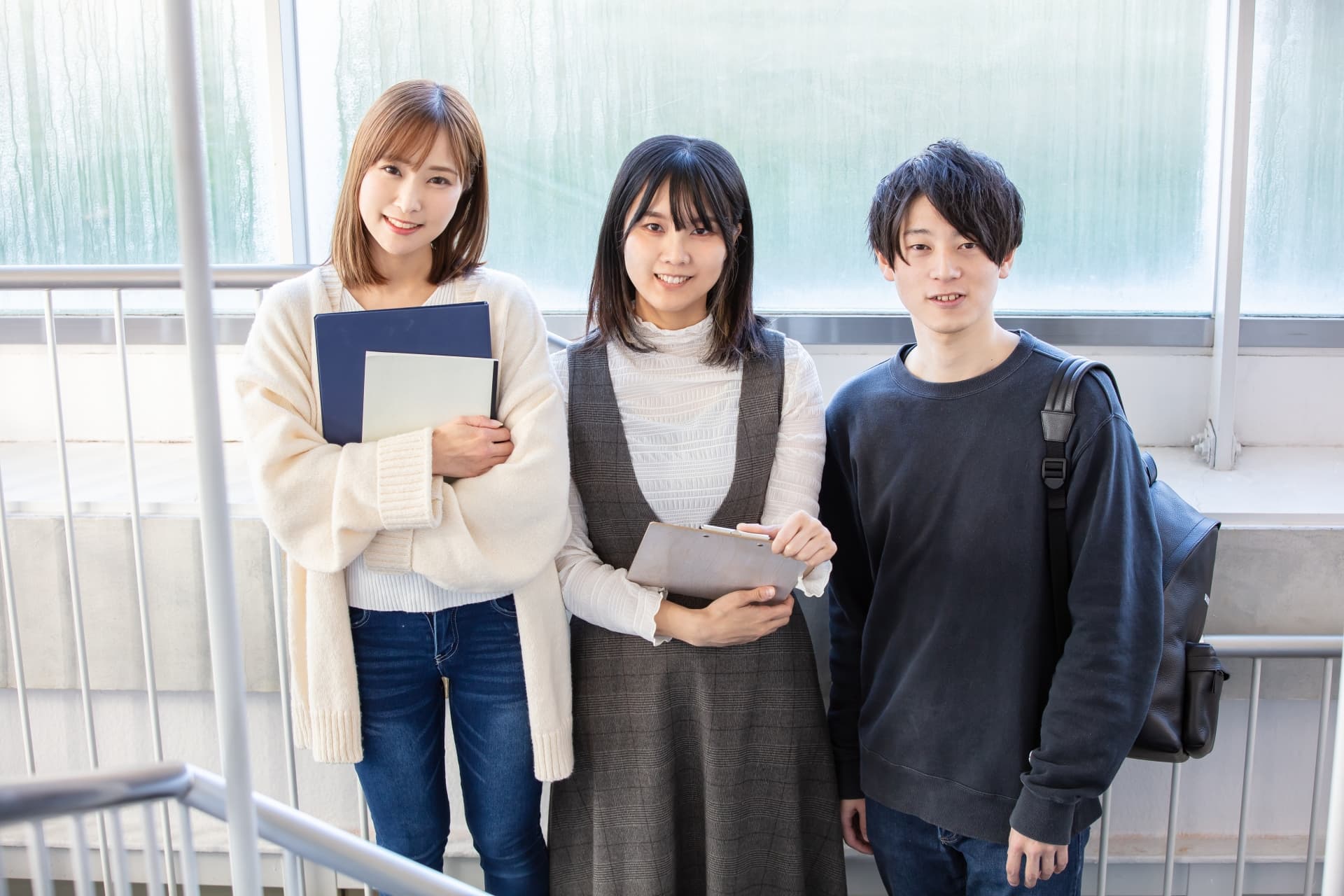 こちらを向いている男女3人